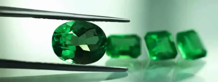 Emerald birthstone in tweezers