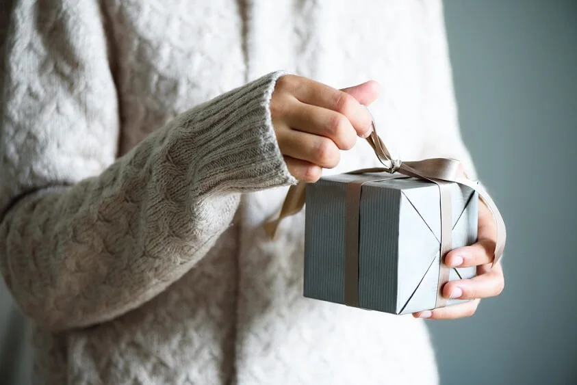 woman holding a holiday gift that she got